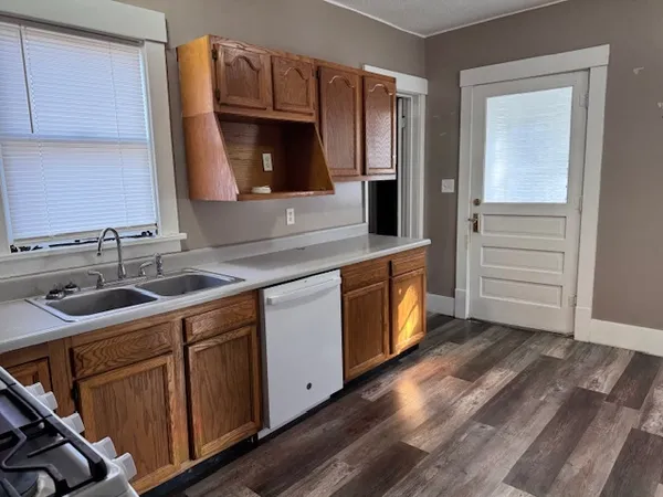 a kitchen with granite countertop wooden cabinets stainless steel appliances and a sink