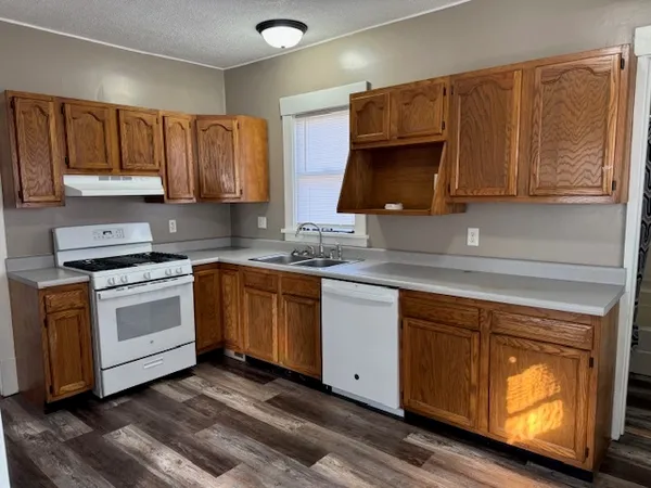 a kitchen with a sink cabinets and wooden floor