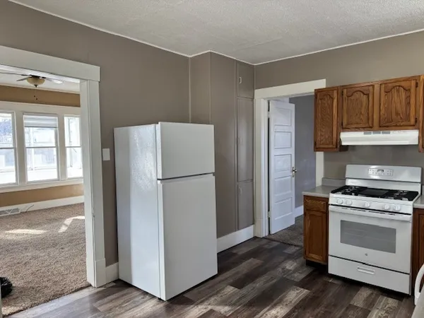 a view of a kitchen with wooden floor and a refrigerator
