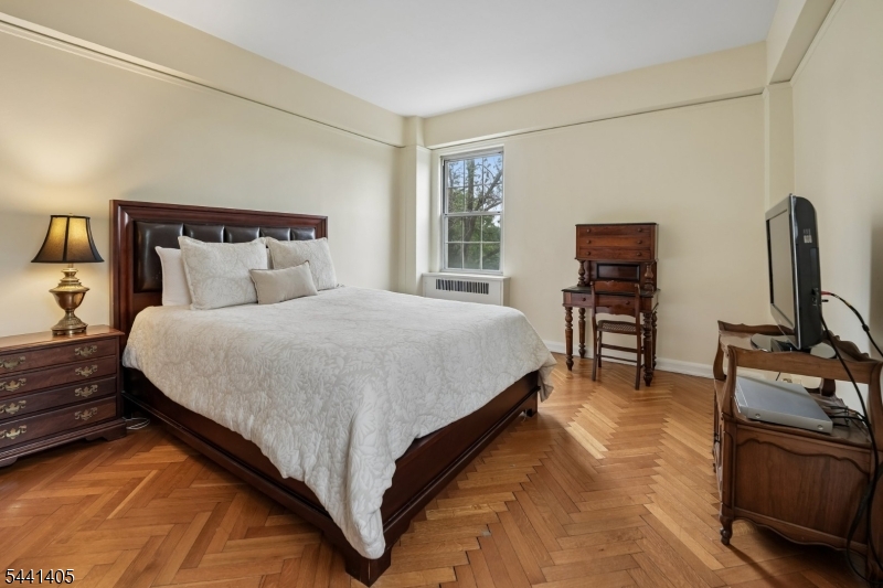 10 Crestmont Road, Unit 2N Montclair, NJ 07042 - Photo 15 of 25 a large bed sitting in a bedroom next to a window with tv