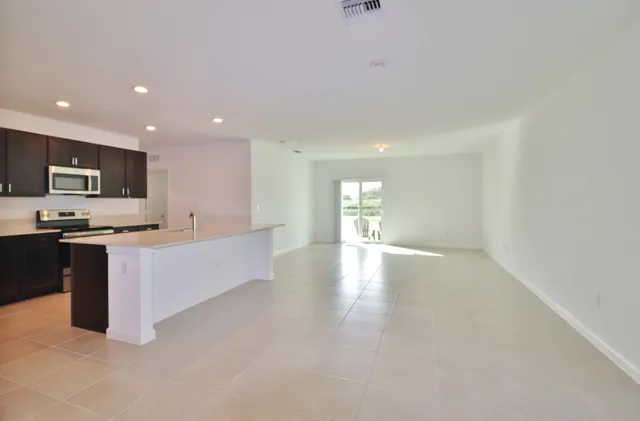 a view of kitchen with kitchen island microwave and cabinets