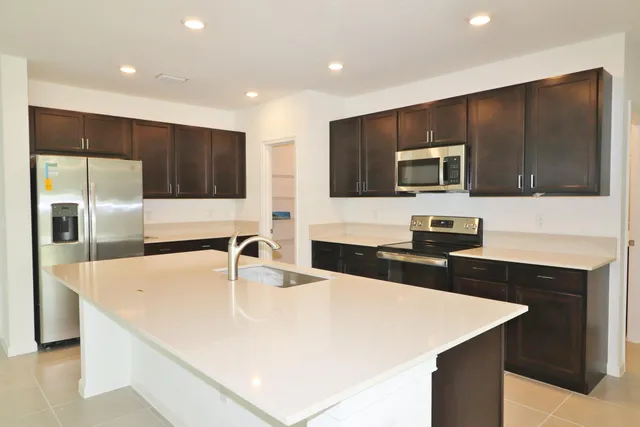 a kitchen with stainless steel appliances a microwave sink and refrigerator