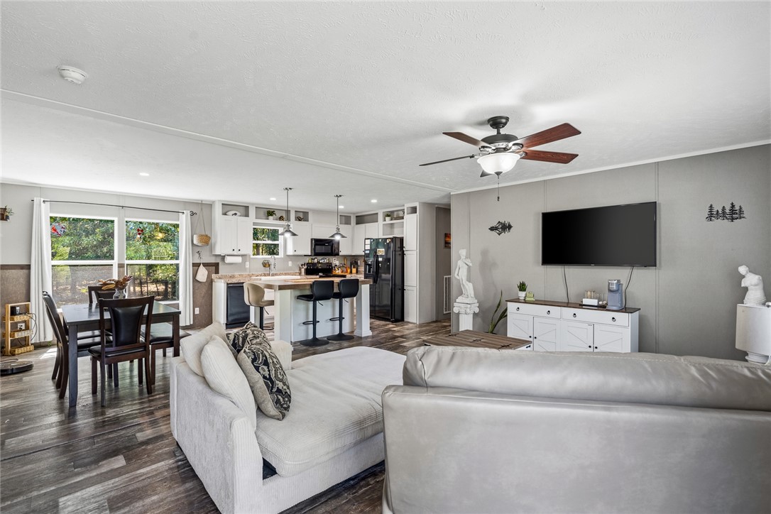 An open-concept layout seamlessly connects the central living area with the kitchen and dining spaces.