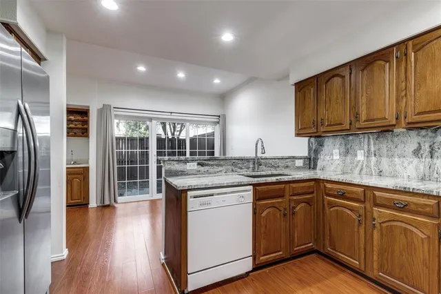 a kitchen with kitchen island granite countertop wooden cabinets and a refrigerator