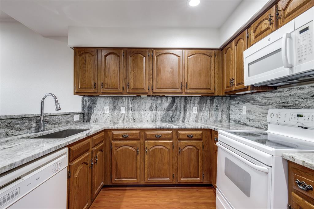 5100 Verde Valley Lane Dallas, TX 75254 - Photo 4 of 12 a kitchen with stainless steel appliances granite countertop a sink a stove and cabinets