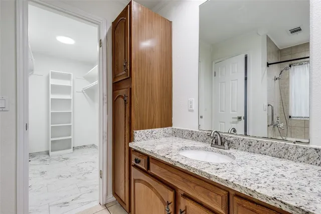 a bathroom with a granite countertop sink and a mirror
