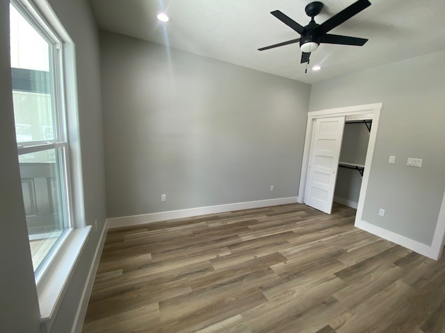 116 Field Street Luling, TX 78648 - Photo 3 of 33 A well-lit bedroom features durable laminate flooring and a functional ceiling fan for optimal comfort.