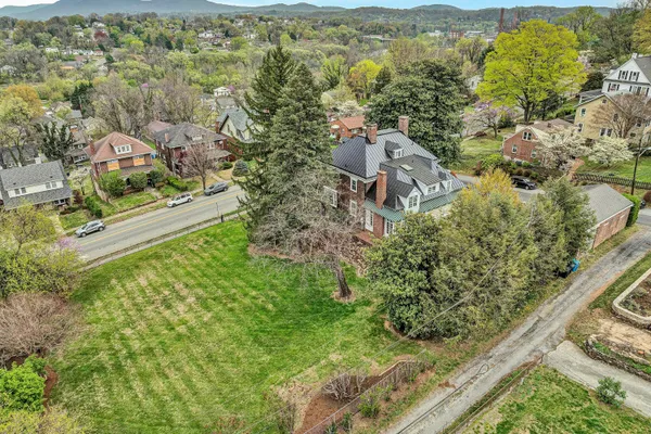 an aerial view of residential houses with outdoor space and trees