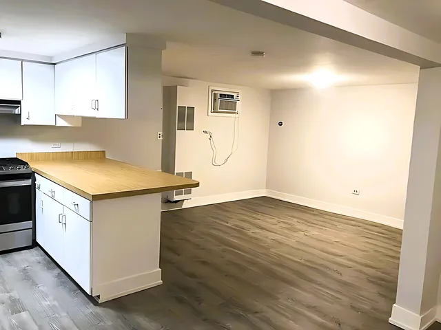 a kitchen with granite countertop white cabinets and wooden floor