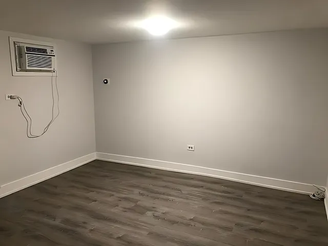 a view of a room with wooden floor and fan