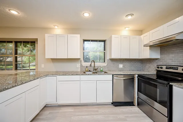 a kitchen with a sink stove and cabinets