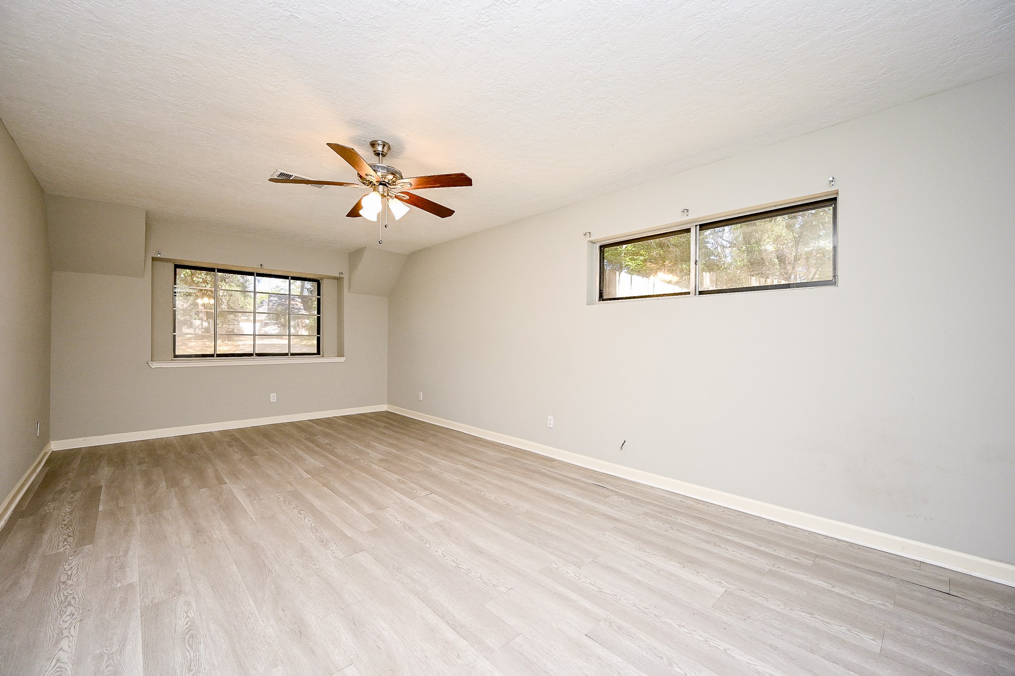 602 Mobile Court Conroe, TX 77302 - Photo 17 of 30 an empty room with wooden floor and windows