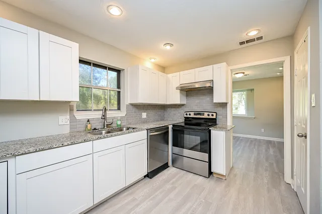 a kitchen with a sink stove and cabinets