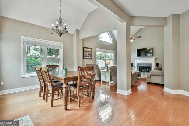 a kitchen with stainless steel appliances granite countertop a stove top oven a sink a dining table and chairs