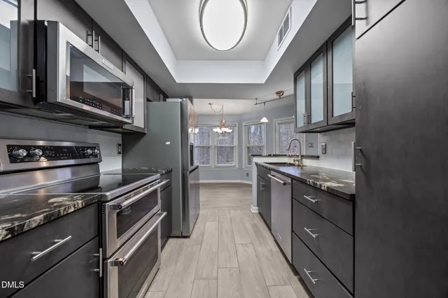 a kitchen with stainless steel appliances granite countertop a stove and a sink
