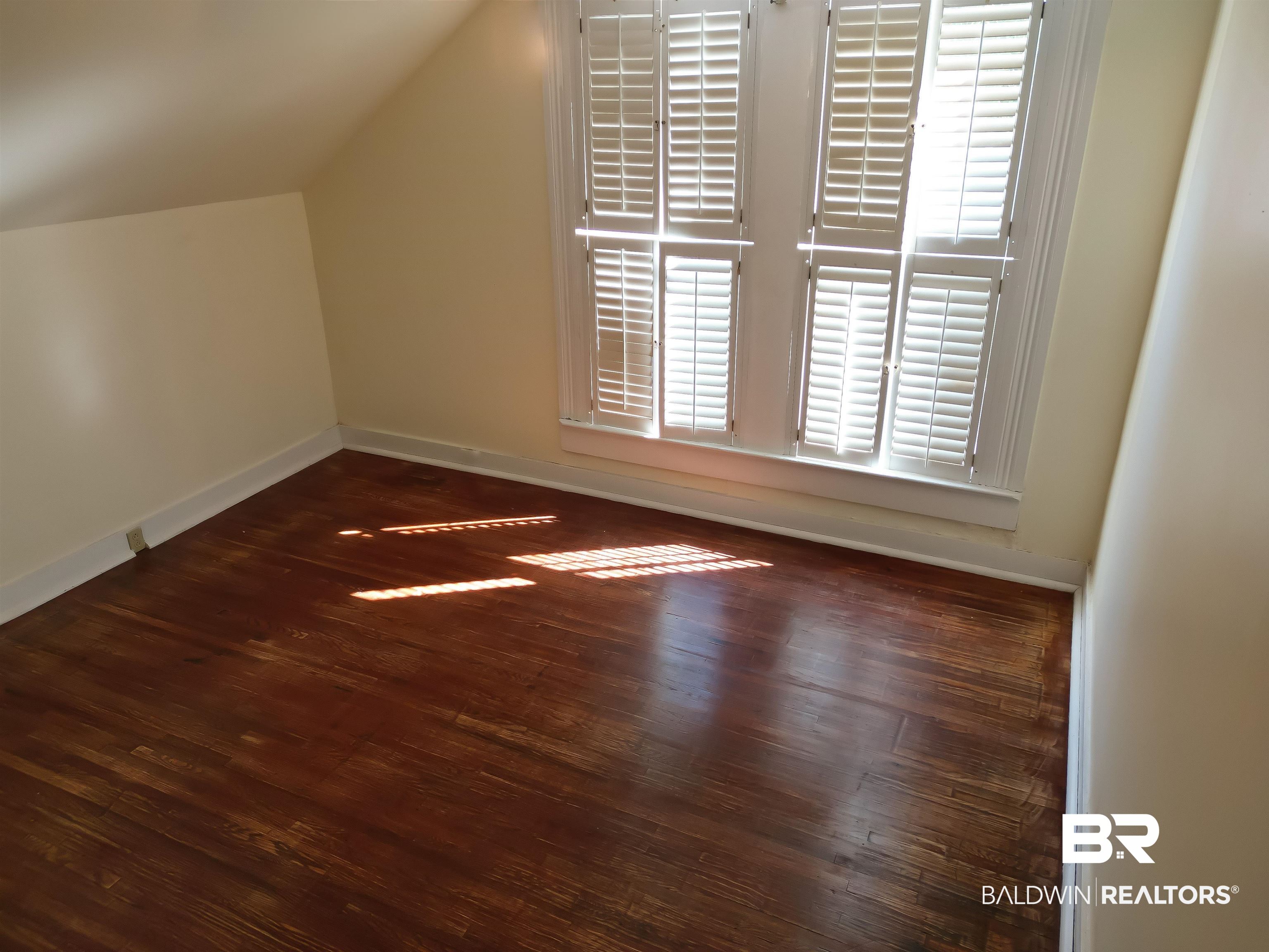73 Liberty Street Monroeville, AL 36460 - Photo 20 of 29 Additional living space featuring a wealth of natural light, lofted ceiling, and dark wood-type flooring