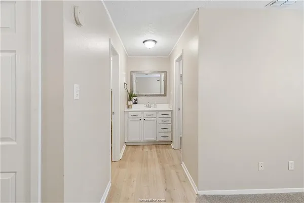 a view of a hallway with white cabinets