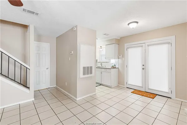 a view of kitchen with white cabinets and refrigerator