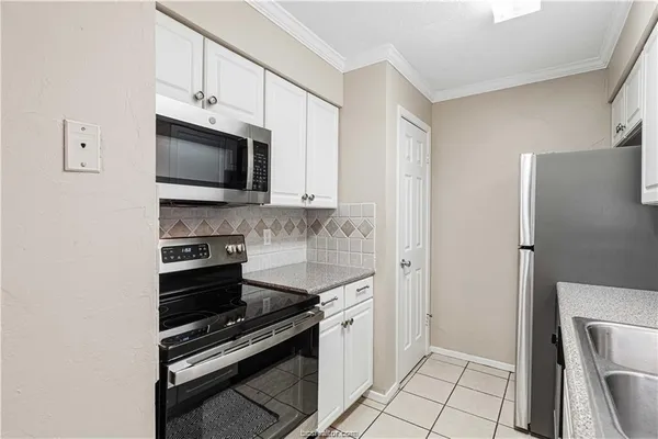 a kitchen with cabinets stainless steel appliances and a counter space