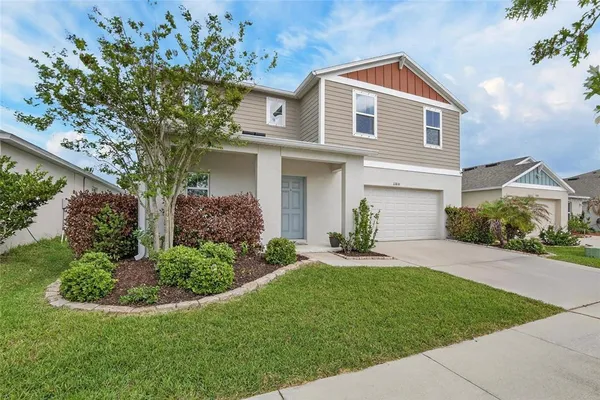 a kitchen with stainless steel appliances kitchen island granite countertop a table chairs refrigerator and microwave