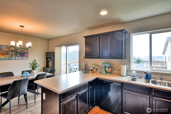 a kitchen with granite countertop a table chairs stove and cabinets