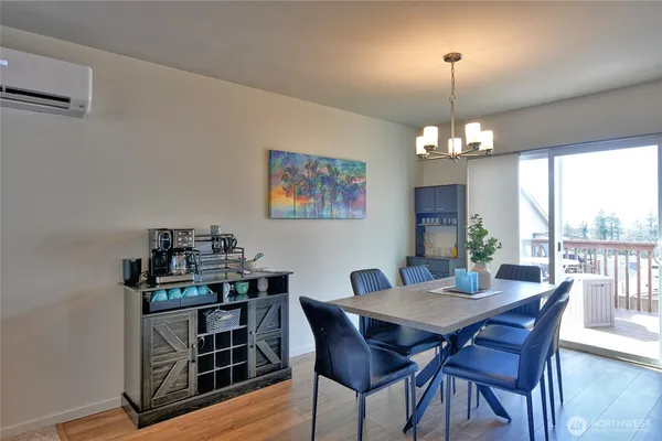 a view of a dining room with furniture a chandelier and wooden floor