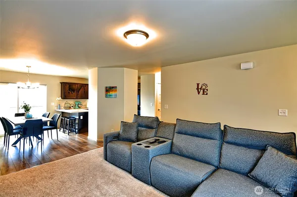 a living room with furniture kitchen view and a large window