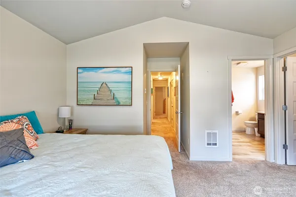 a bedroom with a bed and a painting on the wall