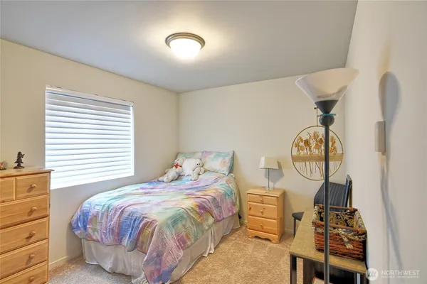 a bedroom with a bed and dresser with mirror
