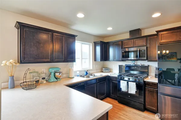 a kitchen with stainless steel appliances granite countertop a sink stove and microwave