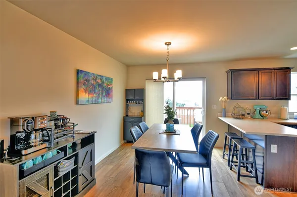 a view of a dining room with furniture a chandelier and wooden floor