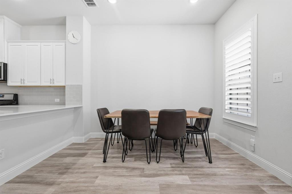 1567 Windermere Way Dallas, TX 75234 - Photo 11 of 26 a view of a dining room with furniture and wooden floor