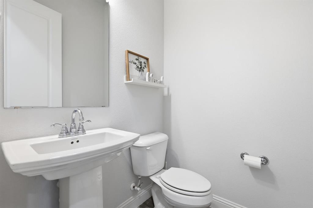 1567 Windermere Way Dallas, TX 75234 - Photo 13 of 26 a bathroom with a sink a toilet and a mirror