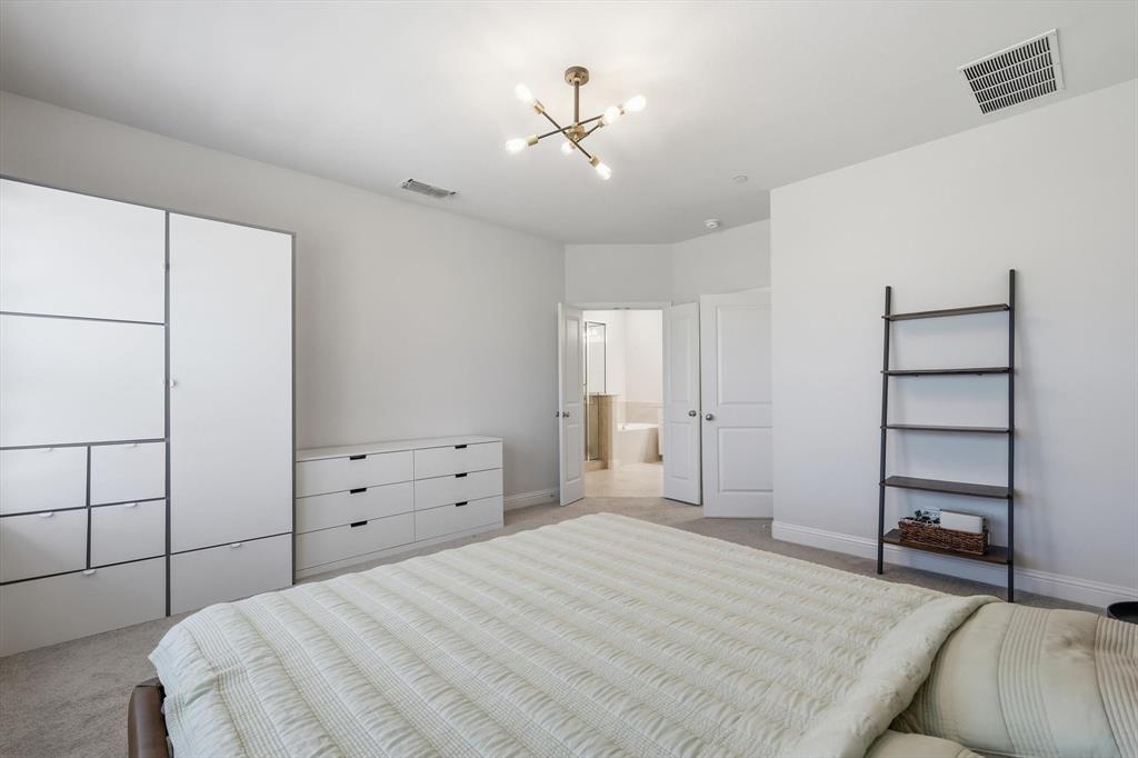 1567 Windermere Way Dallas, TX 75234 - Photo 16 of 26 a bedroom with a bed and a cabinets