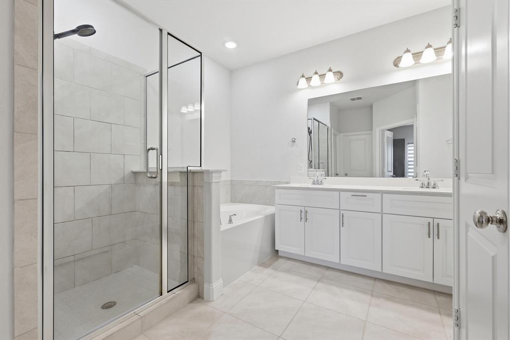 1567 Windermere Way Dallas, TX 75234 - Photo 17 of 26 a spacious bathroom with a shower sink and mirror