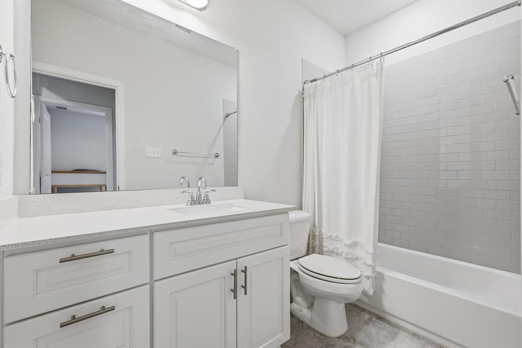 1567 Windermere Way Dallas, TX 75234 - Photo 19 of 26 a bathroom with a granite countertop sink a toilet and a bathtub