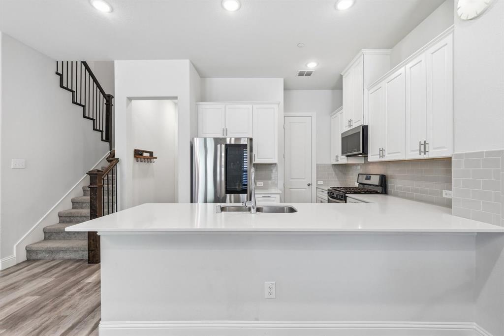 1567 Windermere Way Dallas, TX 75234 - Photo 7 of 26 a kitchen with stainless steel appliances a refrigerator sink and stove