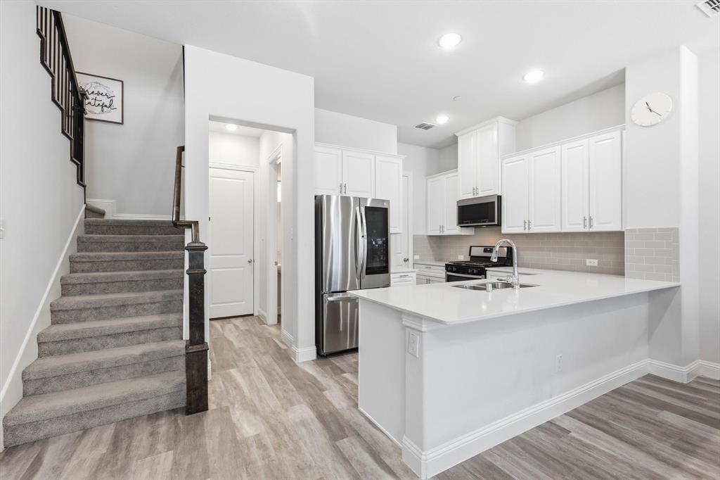 1567 Windermere Way Dallas, TX 75234 - Photo 8 of 26 a kitchen with white cabinets and stainless steel appliances