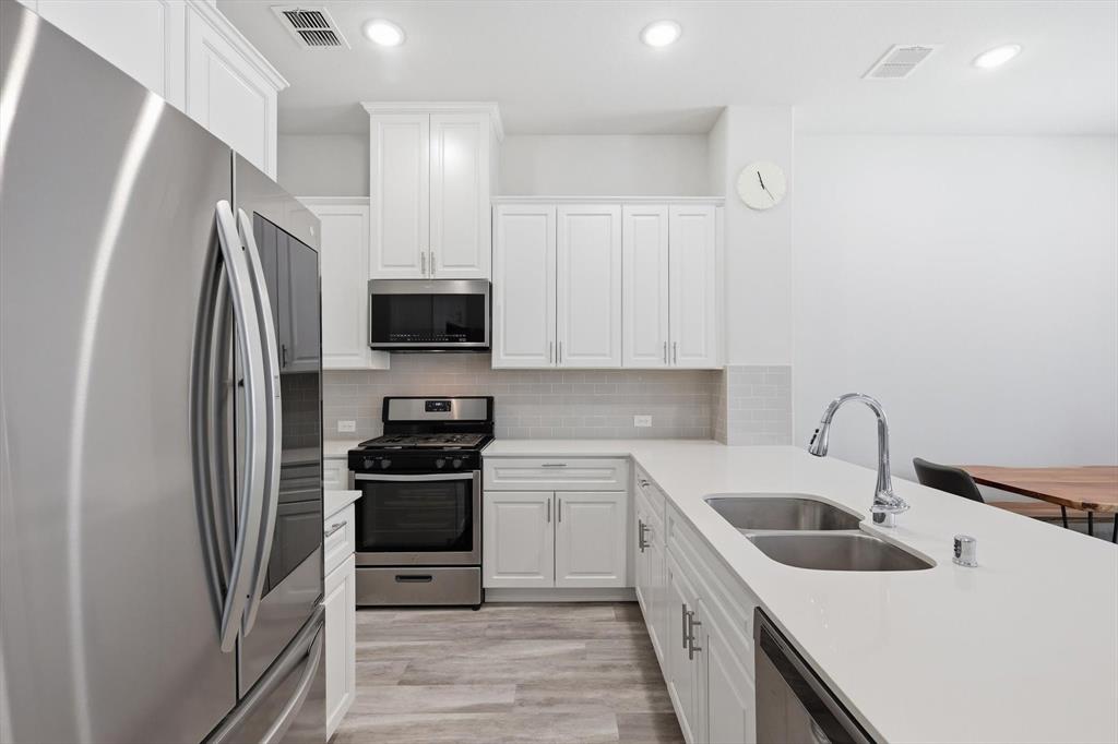 1567 Windermere Way Dallas, TX 75234 - Photo 9 of 26 a kitchen with a sink cabinets and stainless steel appliances