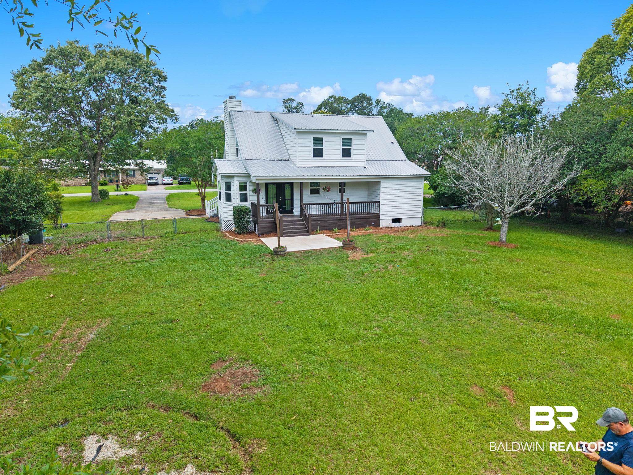 22810 High Ridge Road Fairhope, AL 36532 - Photo 4 of 78 White siding residence featuring a metal roof, covered porch, and elevated deck