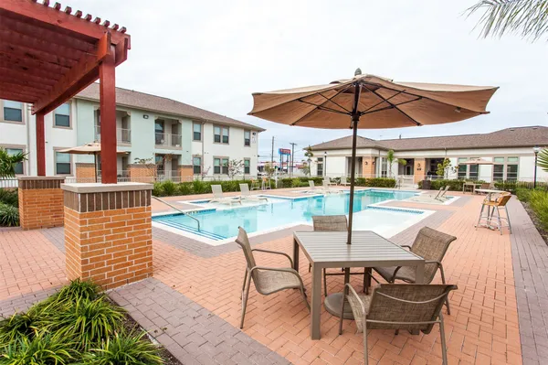 a patio with a table and chairs under an umbrella