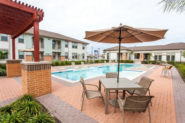 a patio with a table and chairs under an umbrella