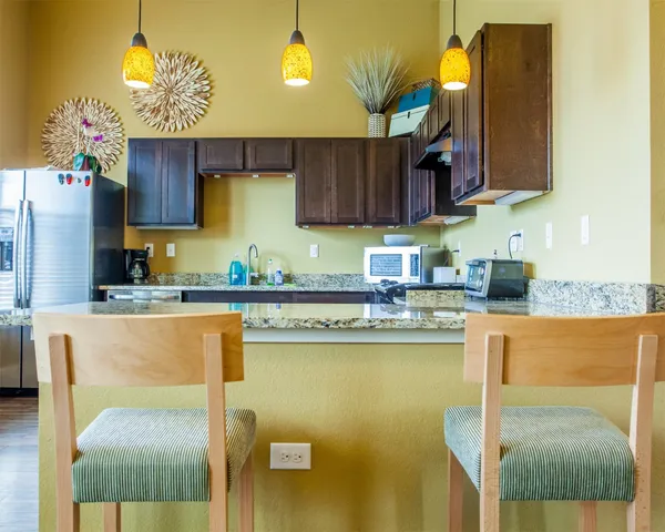 a kitchen with stainless steel appliances granite countertop a sink a stove and a refrigerator