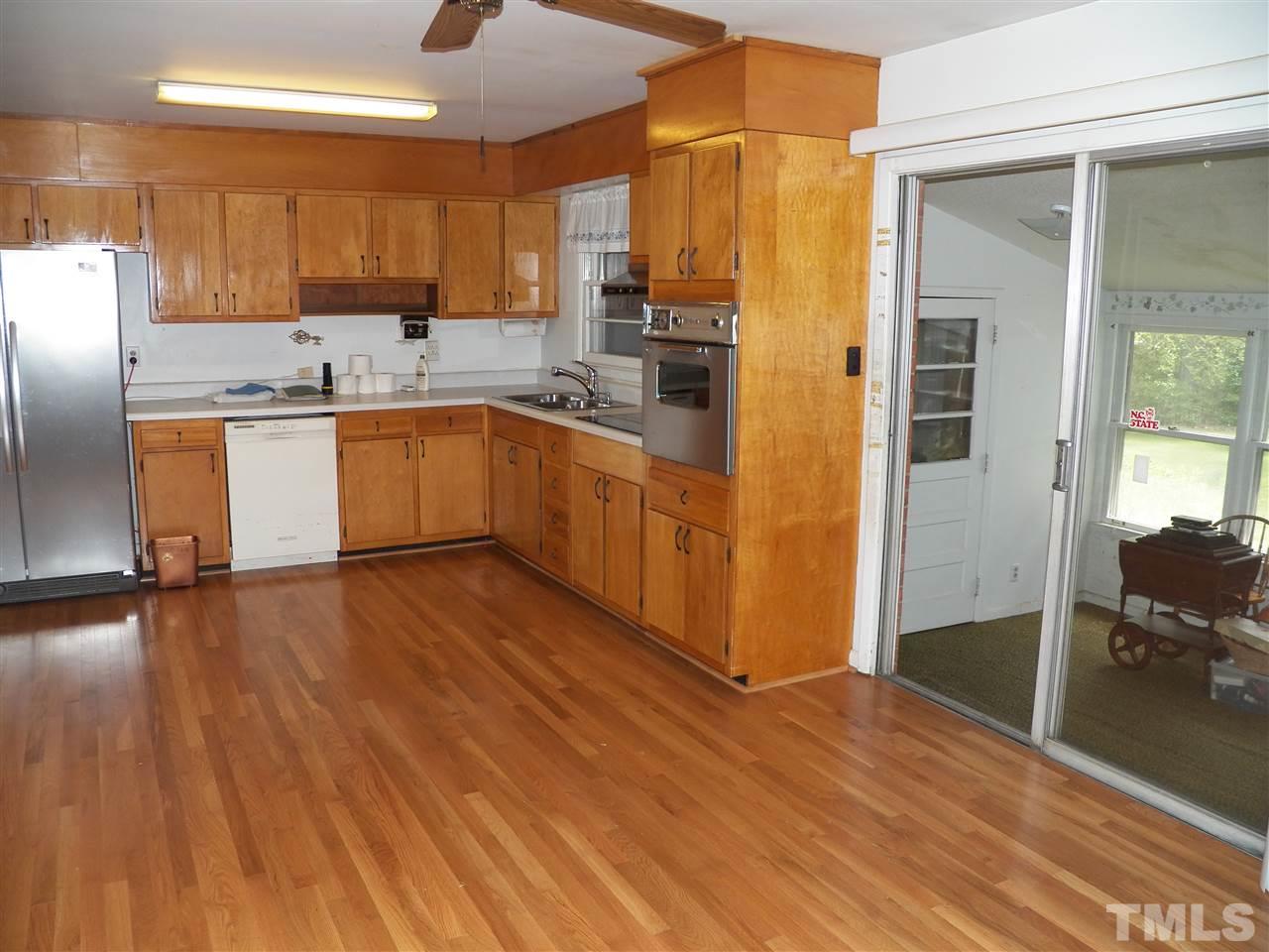 132 East Rowan Street Raleigh, NC 27609 - Photo 8 of 24 a kitchen with stainless steel appliances granite countertop a refrigerator a sink dishwasher a stove with wooden cabinets and floor
