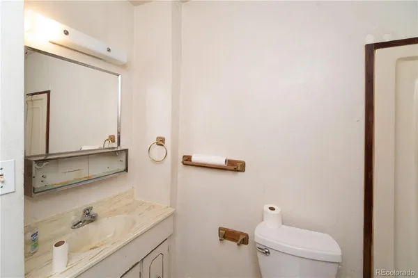 a bathroom with a granite countertop sink mirror and toilet