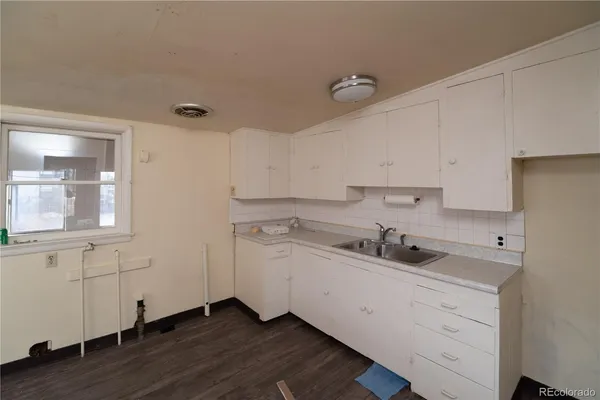 a kitchen with a sink cabinets and wooden floor