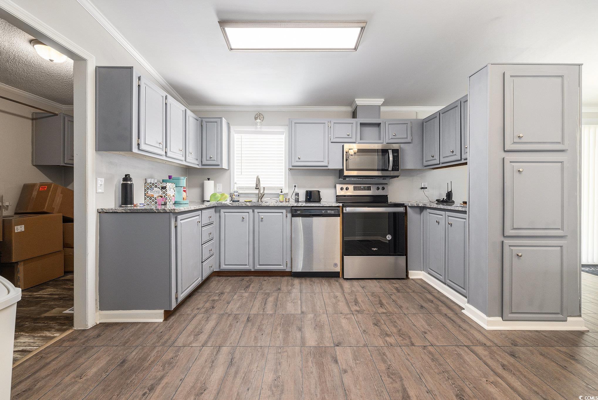 3843 Kelly Road Conway, SC 29526 - Photo 13 of 40 Kitchen featuring appliances with stainless steel finishes, gray cabinetry, ornamental molding, and light wood finished floors
