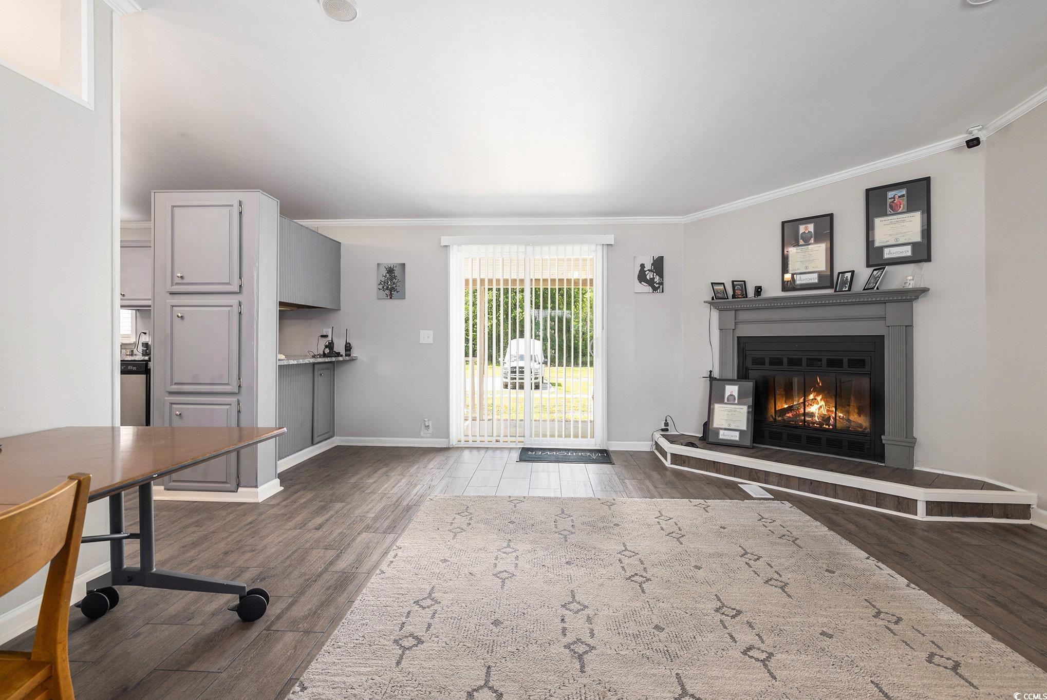3843 Kelly Road Conway, SC 29526 - Photo 8 of 40 Unfurnished living room with crown molding, dark wood finished floors, and a glass covered fireplace