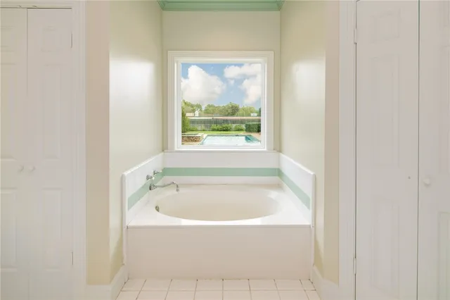 a white bath tub sitting in a bathroom next to a window