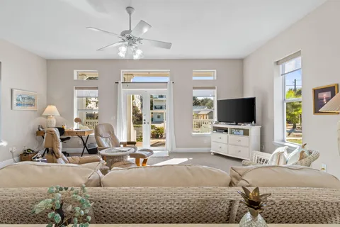 a living room with furniture a flat screen tv and kitchen view
